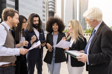 Finansal şehirde işten çıkarken çok ırklı iş arkadaşları konuşuyor