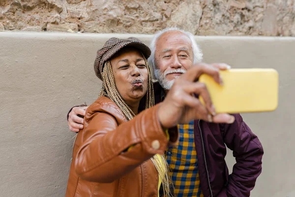 senior couple old asian man and african american woman, make selfie in the city, traveling in retirement