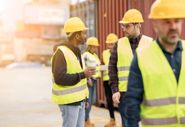 Bir grup lojistik işçisi konteynırların yakınlarını, nakliye ticaretini tartışıyorlar. İş - Hintli adama odaklan -