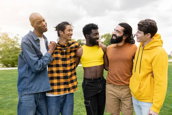 Şehir parkında birbirine sarılan bir grup eşcinsel. Makyajlı transseksüel adam, çok ırklı grup.