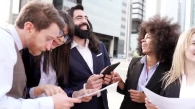 İş arkadaşları dışarıda tartışırken gülüyorlar. Çok ırklı ve melez insanlar ofisten ayrılıyor..