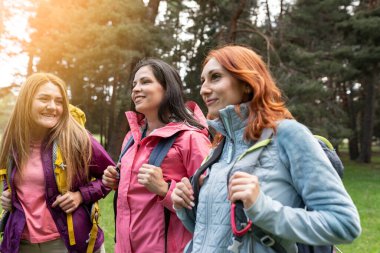 Kafkasyalı olgun kadınlar, gün batımında ormanda gezen sırt çantaları.