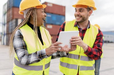Kargo lojistik limanında çok ırklı işçiler - kıdemli Afrikalı kadın ve genç beyaz erkek -