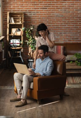 Yetişkin çift, akrabalarıyla evden video görüşmesi yapıyor.