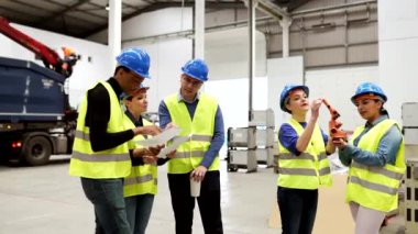 Female investor talking to female engineer and manager at robotics factory, business meeting.