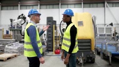 Multiracial engineers shake hands while discussing new projects.