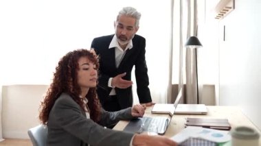 coworkers arguing in office, female intern, focus on asian mature man