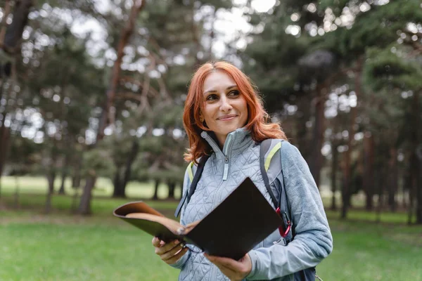 Mujer Madura Con Cuaderno Lectura Naturaleza Mochilero —  Fotos de Stock