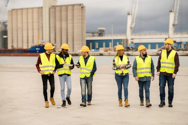 group of multiracial co-workers walking through the port of goods, engineers and warehouse workers.