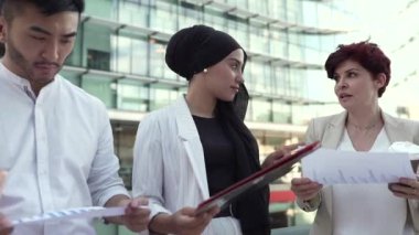 multiracial female business coworkers talking after work
