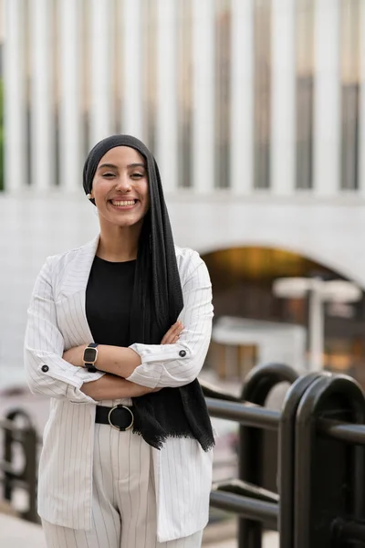 arab business woman with arms crossed in the city, young businesswoman smiling happy