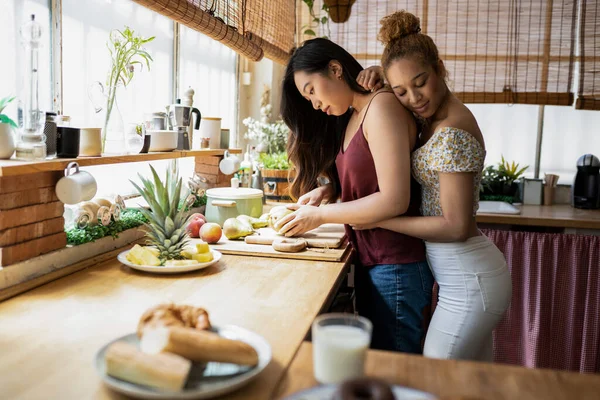 Jong Aziatisch Meisje Snijden Fruit Keuken Terwijl Haar Vriendin Knuffelen — Stockfoto
