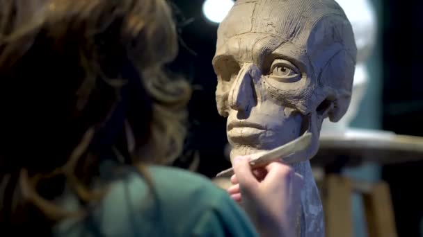 Жінка скульптор на роботі над скульптурою людської голови . — стокове відео
