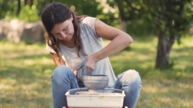 Seramik üretimi. Çömlek çarkında çamurla çalışan kadın..