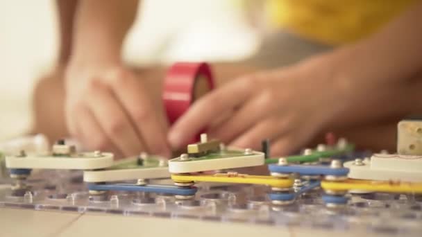 Chlapec hraje hry se stavebnicí. Dítě nadšeně sbírá elektrické obvody. Robotika doma — Stock video