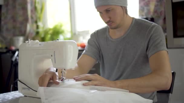 De man naait aan een naaimachine. De naaister werkt. Concept van de kledingproductie — Stockvideo