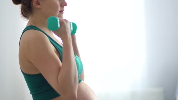 Terhes nő súlyzókkal edz. Egészséges életmód a terhesség alatt. Sporttevékenység — Stock videók