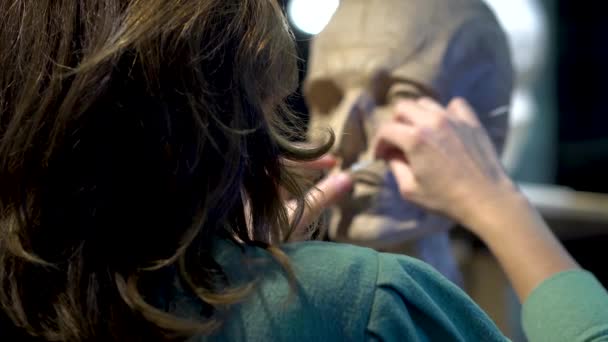 Rzeźbiarka w pracy nad rzeźbą ludzkiej głowy. — Wideo stockowe