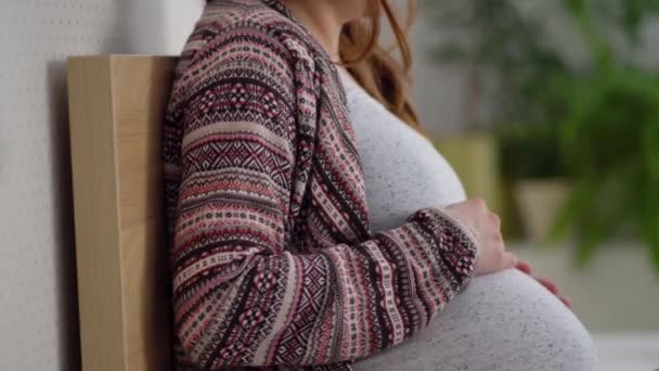 Une jolie femme enceinte s'assoit au lit. Le concept d'une grossesse heureuse. 9 mois d'attente pour un bébé. — Video