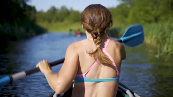 Gölde kayak yapan genç bir kadın. Nehirde kanoyla kürek çeken bir kız. Spor yürüyüşü, su raftingi. — Stok video