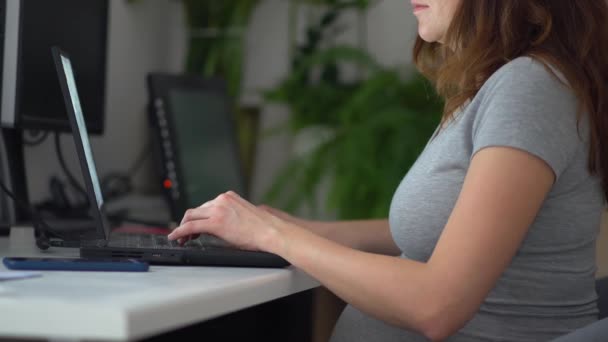 妊婦がノートパソコンで働いている。妊娠中の仕事. — ストック動画