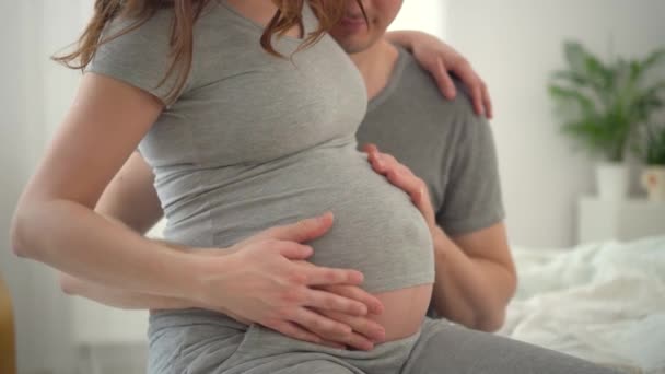 Těhotná žena a její manžel drží ruku v ruce. Rodina je šťastná v očekávání dítěte. — Stock video