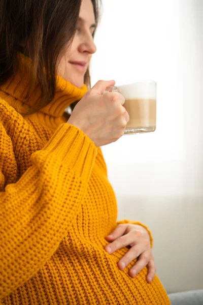 Wanita hamil yang lucu memegang di tangan secangkir kopi. Konsep kehamilan yang bahagia. Minuman tidak sehat — Stok Foto