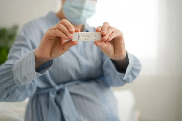 Mujer embarazada haciendo la prueba. Primer plano de los dedos que sostienen prueba de covidio de antígeno expreso, resultado negativo — Foto de Stock