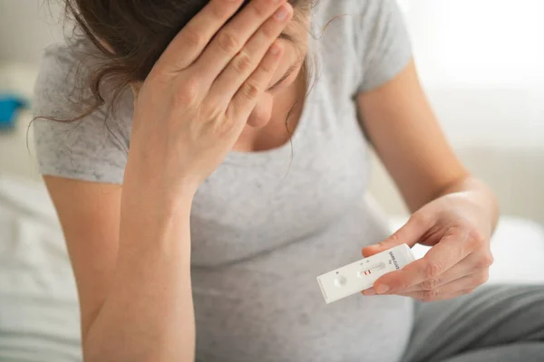 Mujer embarazada haciendo la prueba. Primer plano de los dedos que sostienen prueba de covidio de antígeno expreso, resultado negativo — Foto de Stock