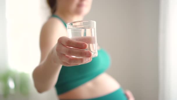 Schwangere hält ein Glas Wasser in der Hand. Gesunder Lebensstil während der Schwangerschaft — Stockvideo