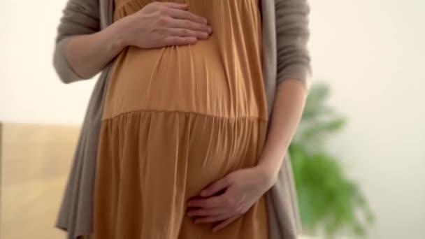 Eine süße schwangere Frau tanzt. Fröhliche Schwangerschaft und positive Einstellung. — Stockvideo