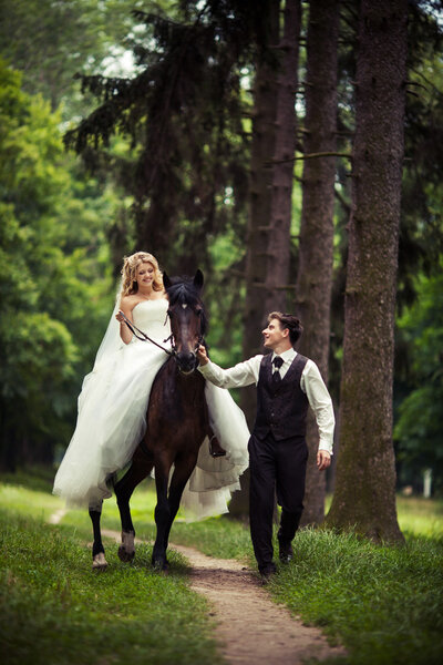 Groom with the bride and a brown horse