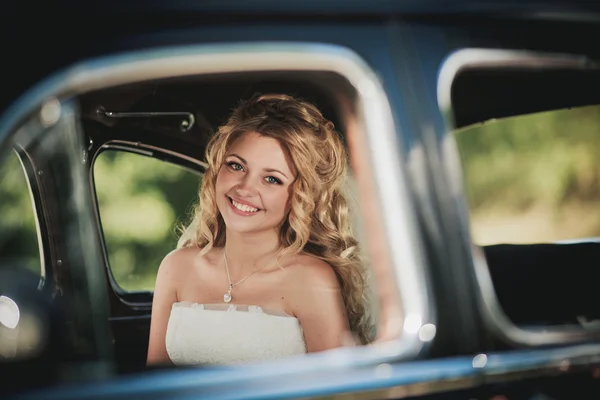 Mariée assis dans la voiture et sourire — Photo