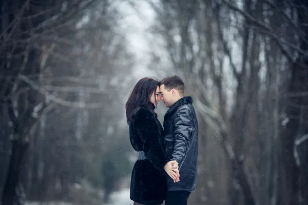 Par i kärlek kyssas i skogen vinter — Stockfoto