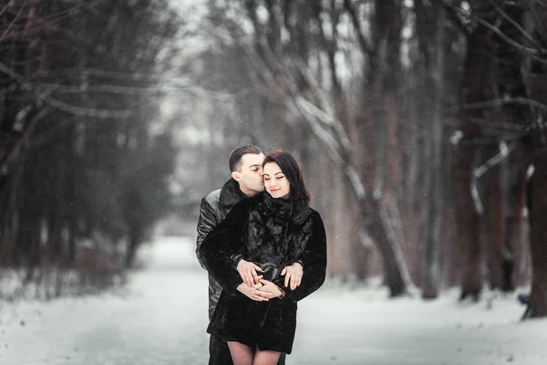 Casal apaixonado beijando na floresta de inverno — Fotografia de Stock