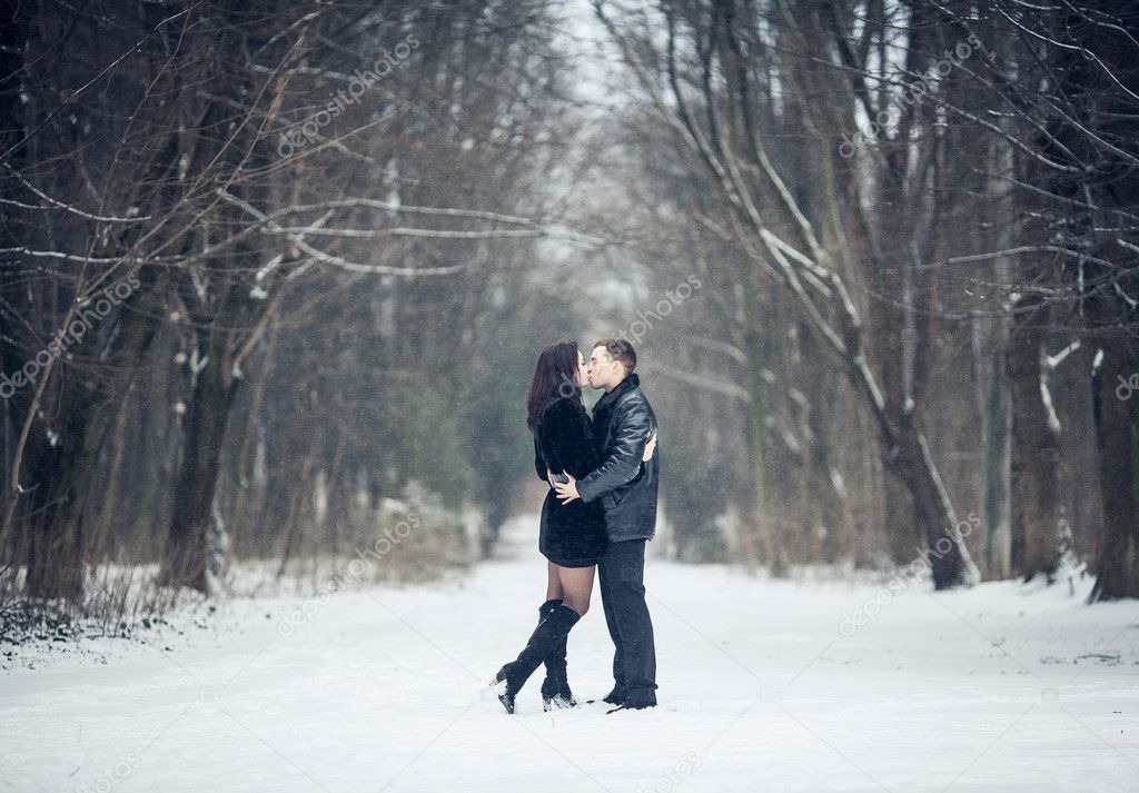 Couple in love kissing in the winter forest