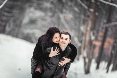 karlı bir ormanda eğleniyor seven Çift