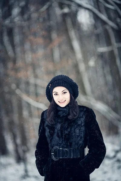 Hermosa chica de pie en un bosque cubierto de nieve —  Fotos de Stock