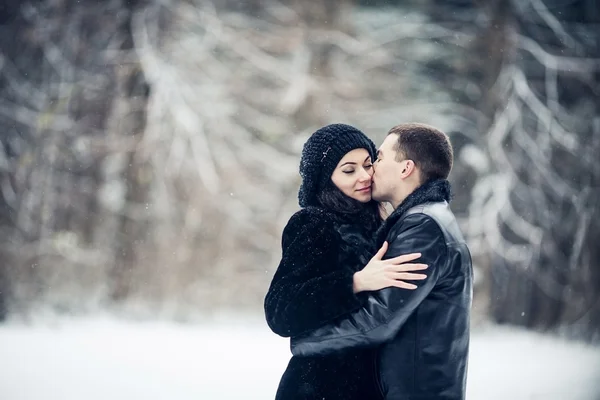 Pareja enamorada besándose en el bosque de invierno — Foto de Stock