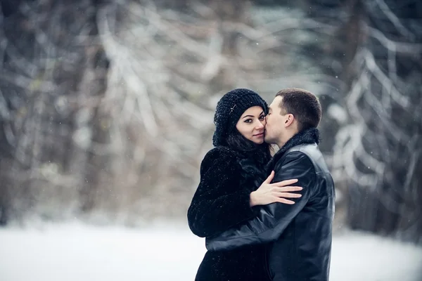 Par i kärlek kyssas i skogen vinter — Stockfoto