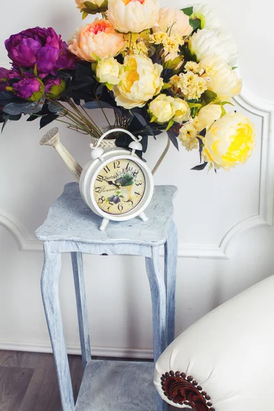 Clock, chair and bouquet of flowers — Stock Photo, Image