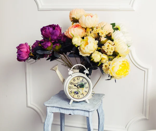 Clock, chair and bouquet of flowers — Stock Photo, Image