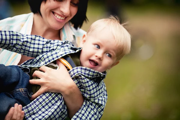 Mãe brincando com seu filho e levantando-o regozijando — Fotografia de Stock