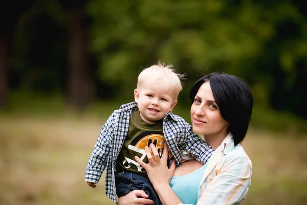 Mãe brincando com seu filho e levantando-o regozijando — Fotografia de Stock