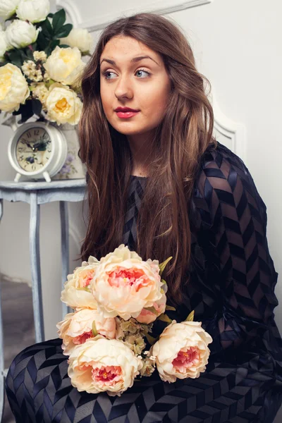 Hermosa chica en un hermoso vestido con un ramo de flores — Foto de Stock