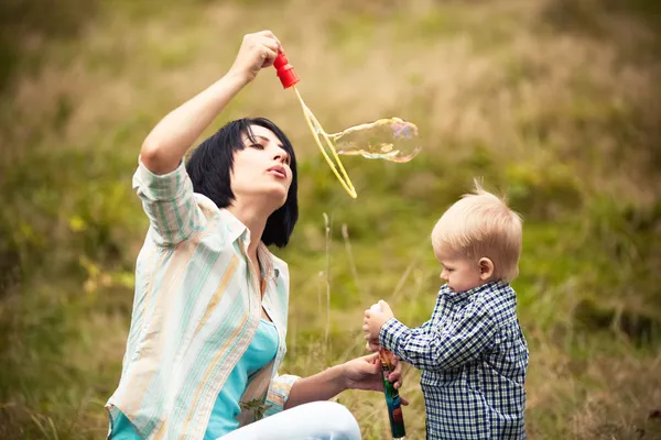 Malý chlapec s bublinami s mámou — Stock fotografie
