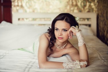 düğün. güzel bir kadın yatak odasında yatağın üstüne yalan