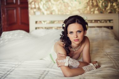 düğün. güzel bir kadın yatak odasında yatağın üstüne yalan