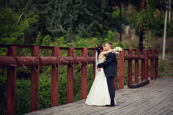 Matrimonio. Sposi felici a un matrimonio una passeggiata sul ponte — Foto Stock