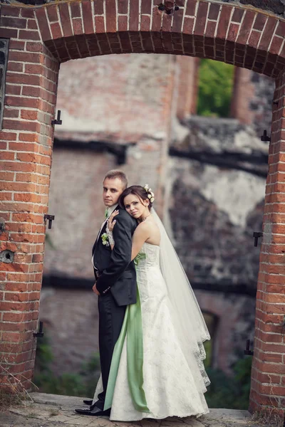 Boda. novia y novio abrazándose contra el telón de fondo de un edificio viejo —  Fotos de Stock